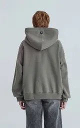 Hoodie color verde militar de frisa gamuzada 100% algodón, de calce oversize crop. Tiene bolsillo canguro y capucha forrada.