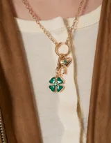 Collar corto dorado con cadena de eslabones, cierre de mosquetón y dijes colgantes de corazón, trébol de resina verde y herradura.