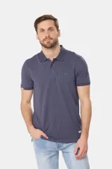 Polo de piqué color azul oscuro con un mini estampado geométrico repetitivo en todo el cuerpo. Presenta cuello y tapeta de botones en color liso, y un pequeño logo bordado en el pecho.