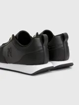 Zapatillas deportivas Tommy Hilfiger negras de cuero sintético, con cordones y suela blanca.