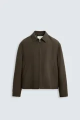 Sobrecamisa marrón oscuro confeccionada en tejido de lana italiano. Tiene cuello solapa, manga larga con puños abotonados, bolsillos de vivo en la cadera y cierre frontal con cremallera.