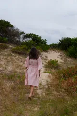 Túnica de corte holgado con estampado a cuadros en tonos rosa y crudo, con cuello redondo y mangas cortas amplias. Incluye cinturón de la misma tela para ajustar a la cintura.