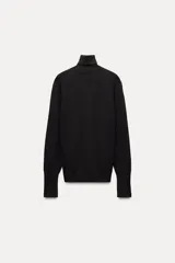 Jersey negro de punto liso con cuello alto, manga larga y detalle de botones dorados en los puños.