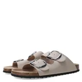 Sandalias planas color beige con dos tiras anchas con hebillas metálicas plateadas.