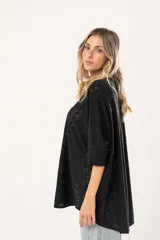 Camisa negra con calados, escote en V, abotonada y manga 3/4.