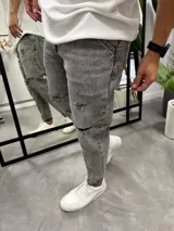 Jean gris con efecto lavado, corte slouchy, tiro medio y roturas en las rodillas.