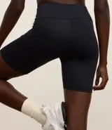 Bermuda deportiva de poliamida negra, tiro alto y calce ajustado.