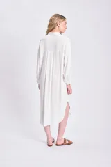 Vestido camisero largo color blanco, con cuello mao, abotonadura frontal y mangas largas abullonadas con puños camiseros.