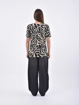 Remera blanca con estampado de manchas negras tipo animal print.