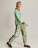 Pantalón cargo de viscosa con estampado de sombreros de vaquero, cactus y vaqueros a caballo. Tiene dos bolsillos laterales y dos bolsillos grandes en la rodilla. Cintura elástica.