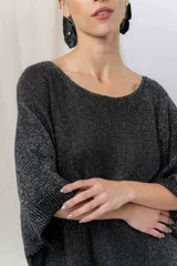 Vestido-buzo tejido de silueta oversize con hilado jaspeado en brillo, escote redondo, mangas amplias tipo murciélago y terminaciones acanaladas en ruedo y puños.