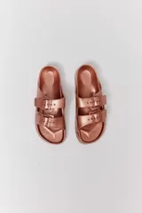 Sandalias de goma color rosa metalizado, con dos correas ajustables con hebilla.