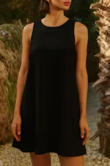 Vestido corto negro de lino y rayón, con cuello redondo, sisas bajas y ruedo ancho.