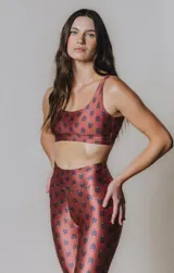 Top deportivo color ladrillo con estampado de cachemir en tonos azules, escote en U, breteles medios y tiras cruzadas en la espalda.