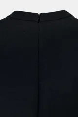 Vestido corto negro con cuello redondo y escote pico frontal, manga corta abullonada y cintura entallada. Presenta tapetas decorativas en la parte inferior delantera.