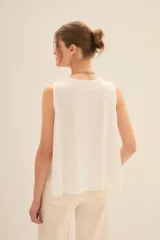 Musculosa blanca de algodón con cuello redondo y sisas amplias.