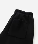 Pantalón baggy color beige, confeccionado en algodón con felpa. Presenta cintura elástica con cordón ajustable, bolsillos delanteros y un bolsillo trasero. El bajo es ajustable con elástico.