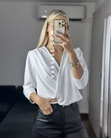 Blusa negra con estampado de lunares blancos, escote en V cruzado, mangas 3/4 abullonadas y hombreras. Talle único abarca hasta L.