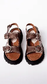 Sandalias marrones con suela track y tiras anchas con hebillas metálicas.