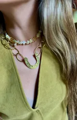 Gargantilla corta con cuentas de piedra color amarillo pálido y dije de herradura dorada.