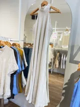 Vestido largo confeccionado en 100% lino, con cuello halter y silueta fluida en color beige.