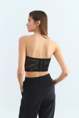 Corset negro strapless de encaje con copas preformadas y varillas de soporte.