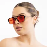Lentes de sol con marco negro, patillas plateadas y lentes celestes.
