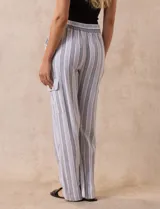 Pantalón cargo de lino color blanco, marca Marissa Olivia. Tiene pretina ancha elastizada con lazo de ajuste, bolsillos inclinados delanteros y bolsillos laterales con botón.