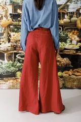 Pantalón de lino color crudo con finas rayas verticales negras, corte wide leg y tiro alto.