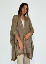 Ruana marrón de tejido de punto calado con terminación de crochet.