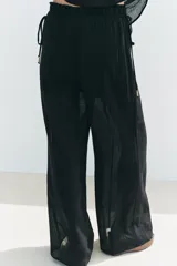 Pantalón negro de tiro alto con cintura elástica ajustable con cordones laterales, forro interior corto y pernera ancha.