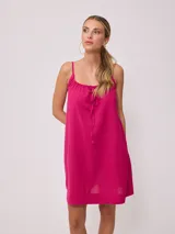 Vestido corto de algodón y lino color negro, con tirantes finos y escote recto con lazo ajustable.