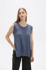 Remera azul de viscosa con cuello redondo y mangas cortas con volados. Corte holgado y largo a la cadera.