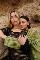 Vestido corto negro tejido a crochet con mangas largas y espalda descubierta.