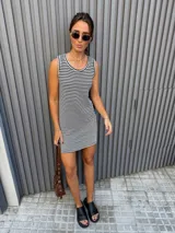 Vestido corto tejido a rayas horizontales en blanco y negro, sin mangas y con cuello redondo.