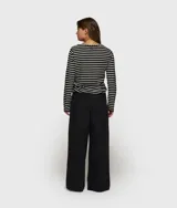 Pantalón ancho negro de corte relajado, confeccionado en mezcla de algodón y lino. Presenta cinturilla elástica de punto con cordón y trabillas, bolsillos laterales inclinados, etiqueta sobre el bolsillo izquierdo, minirayas bordadas bajo el bolsillo izquierdo y un bolsillo de ribete doble en la espalda.