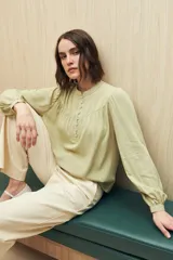 Camisa celeste de manga larga en viscosa suave, con cuello mao y botonadura parcial al frente. El detalle de frunces en los hombros y los puños abotonados le suman delicadeza y estilo.