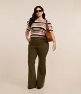 Pantalón flare color verde militar confeccionado en sarga con elastano, tiro alto, cintura ancha con trabillas, doble botón, cierre por cremallera, bolsillos y detalle de recortes.