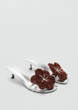 Sandalias plateadas con tacón kitten y detalle de flor tejida color marrón.