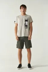 Bermuda cargo color verde militar con bolsillos laterales con cierre y logo metálico.