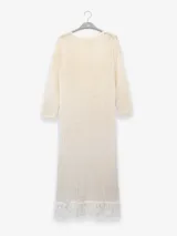 Vestido largo color crudo, tejido en punto abierto de algodón con lúrex y flecos en el ruedo.