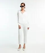 Camisa blanca de satén con cuello inglés, manga larga y cierre frontal con botones.
