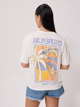 Remera color amarillo claro con estampado en el frente que incluye un sol y el texto 'Rusty Club'. Corte holgado.