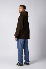 Buzo canguro marrón con capucha, confeccionado en frisa gruesa de algodón con recortes y calce oversize.