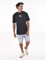Remera negra de corte oversized con estampado circular en el pecho que incluye una palmera, una ola y la palabra 'Paradise'.