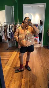 Campera puffer color camel con estampado de cachemir y figuras geométricas en amarillo pálido.
