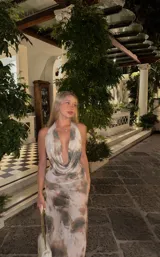 Vestido largo de microtul con estampado tie-dye en tonos beige y marrón, escote halter con espalda descubierta y falda con transparencia.