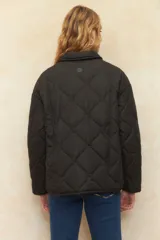 Campera capitoneada color verde militar, con botones veteados, bolsillos laterales con solapa y forro de satén con estampado animal print.