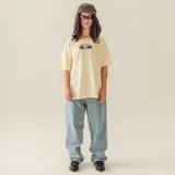 Remera color beige con estampado de un radiograbador y el nombre de la banda Limp Bizkit.