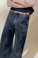 Pantalón de jean denim 100% algodón con tiro medio y piernas anchas, con 5 bolsillos y detalle de pespuntes a contra tono.